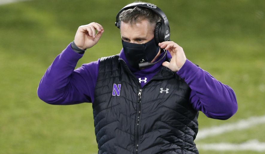 FILE - Northwestern coach Pat Fitzgerald walks on the field during the fourth quarter of the team's NCAA college football game against Michigan State in East Lansing, Mich., in this Saturday, Nov. 28, 2020, file photo. Pat Fitzgerald figures he'll add a few more gray hairs by the time No. 15 Northwestern steps on the field to face No. 3 Ohio State in the Big Ten championship game on Saturday, Dec. 19. Then again, if Northwestern wins? “Not gonna lie to you, it would be a helluva ride home on I-65,” Fitzgerald said. (AP Photo/Al Goldis, File)