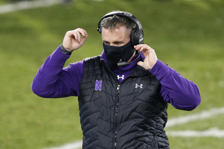 FILE - Northwestern coach Pat Fitzgerald walks on the field during the fourth quarter of the team's NCAA college football game against Michigan State in East Lansing, Mich., in this Saturday, Nov. 28, 2020, file photo. Pat Fitzgerald figures he'll add a few more gray hairs by the time No. 15 Northwestern steps on the field to face No. 3 Ohio State in the Big Ten championship game on Saturday, Dec. 19. Then again, if Northwestern wins? “Not gonna lie to you, it would be a helluva ride home on I-65,” Fitzgerald said. (AP Photo/Al Goldis, File)
