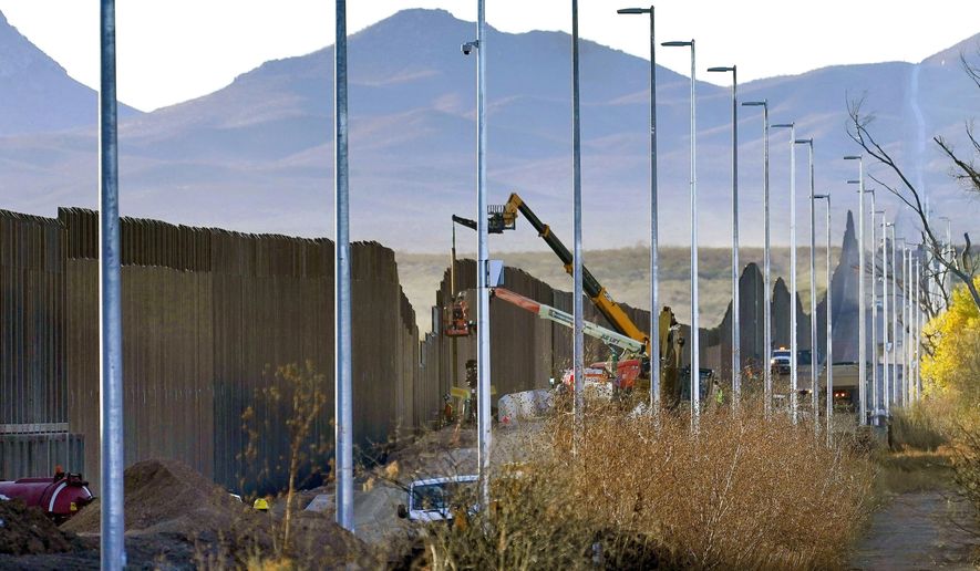 Crews construct a section of border wall in San Bernardino National Wildlife Refuge, Tuesday, Dec. 8, 2020, in Douglas, Ariz.  Construction of the border wall, mostly in government owned wildlife refuges and Indigenous territory, has led to environmental damage and the scarring of unique desert and mountain landscapes that conservationists fear could be irreversible. (AP Photo/Matt York)