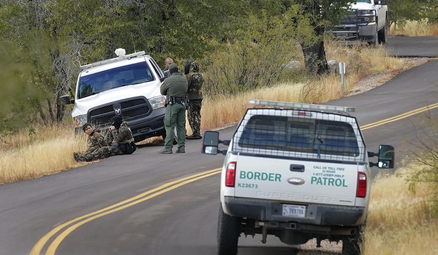 A pair of Customs and Border Patrol agents detain three migrants leading up to Montezuma&#39;s Pass in Coronado National Memorial, Thursday, Dec. 10, 2020, in Hereford, Ariz.   Construction of the border wall, mostly in government owned wildlife refuges and Indigenous territory, has led to environmental damage and the scarring of unique desert and mountain landscapes that conservationists fear could be irreversible. (AP Photo/Matt York)