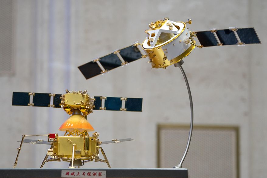 A model of China's Chang'e 5 lunar orbiter and lander are displayed before a press conference at the State Council Information Office in Beijing, Thursday, Dec. 17, 2020. Following the successful return of moon rocks by its Chang'e 5 robotic probe, China is preparing for future missions that could set the stage for an eventual lunar base to host human explorers. (AP Photo/Mark Schiefelbein)