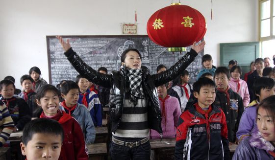 Singer Tan Weiwei, center, gives a singing lesson to students in a rural primary school in Dabo village in Lianyuan city in southern China&#39;s Hunan Province on Dec. 4, 2007. Tan&#39;s latest song &amp;quot;Xiao Juan,&amp;quot; has captivated many on the Chinese internet and has set off a discussion on domestic violence. (Chinatopix via AP)