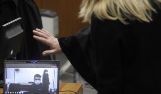 Gabriel Natale-Hjorth, right, connected from the jailhouse to the courtroom, is greeted by his mother Heidi Hjorth, during a hearing in the trial in which he is accused of killing paramilitary police officer Mario Cerciello Rega, in Rome, Thursday, Dec. 17, 2020. Finnegan Lee Elder and Gabriel Natale-Hjorth both from California are accused of murdering the police officer during a summer vacation in Italy in July 2019. (AP Photo/Gregorio Borgia, Pool)