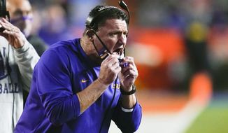 LSU coach Ed Orgeron shouts instructions to players on the field during the first half of the team&#39;s NCAA college football game against Florida, Saturday, Dec. 12, 2020, in Gainesville, Fla. (AP Photo/John Raoux)