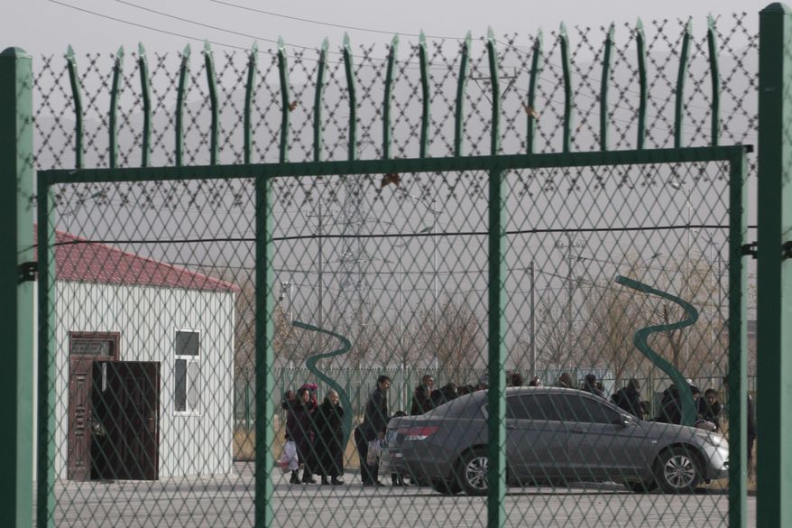 In this Dec. 3, 2018, file photo, people line up at the Artux City Vocational Skills Education Training Service Center at the Kunshan Industrial Park in Artux in western China's Xinjiang region. Groups representing ethnic minorities in China are again accusing the International Olympic Committee of ignoring widespread human rights abuses as the country prepares to hold the 2022 Winter Olympics in Beijing. Rights groups representing Tibetans, Uighurs, and others have sent an open letter to IOC President Thomas Bach and IOC member Juan Antonio Samaranch, who oversees preparations for the Beijing Games.(AP Photo/Ng Han Guan, File)