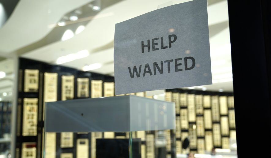 A Help Wanted sign is posted at a Designer Eyes store at Brickell City Centre, Friday, Nov. 6, 2020, in Miami. The number of people applying for unemployment aid jumped last week to 853,000, the most since September, evidence that some companies are cutting more jobs as new virus cases spiral higher. The Labor Department said Thursday, Dec. 10,  that the number of applications increased from 716,000 the previous week.  (AP Photo/Lynne Sladky)