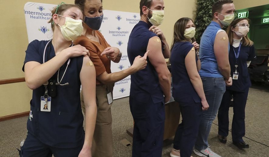 Registered nurse Sophie Woodbury, left, poses for a photo with state epidemiologist Dr. Angela Dunn, and fellow registered nurses Monte Roberts, Amanda Vicchrilli, William Brunt and Julie Nelson at LDS Hospital in Salt Lake city on on Tuesday, Dec. 15, 2020. Woodbury, Roberts, Vicchrilli and Burnt were vaccinated for the coronavirus by Nelson. (Jeffrey D. Allred/The Deseret News via AP)