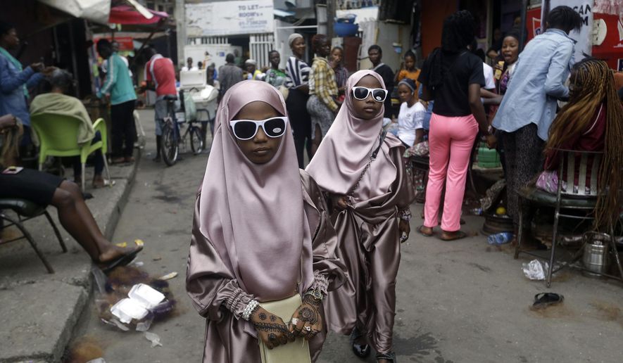 Muslim girls walk through a street after prayers in Lagos, Nigeria, Friday, July 31, 2020. (AP Photo/Sunday Alamba, File)
