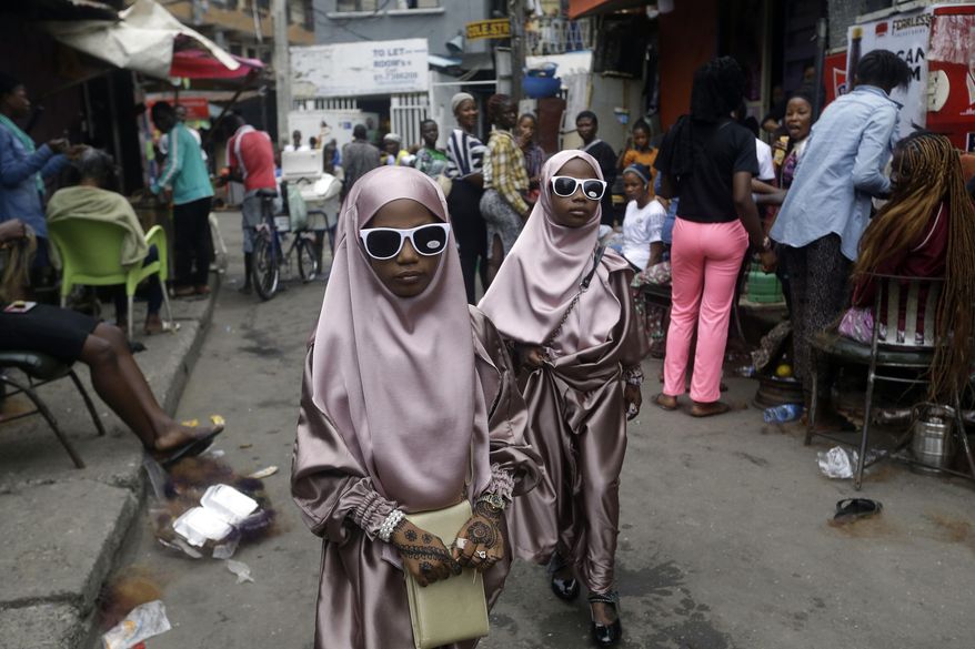 Muslim girls walk through a street after prayers in Lagos, Nigeria, Friday, July 31, 2020. (AP Photo/Sunday Alamba, File)