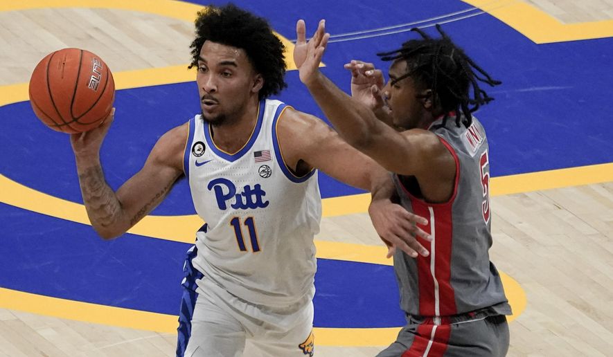 Pittsburgh's Justin Champagnie (11) passes as Gardner Webb's Jamaine Mann defends during the second half of an NCAA college basketball game, Saturday, Dec. 12, 2020, in Pittsburgh. (AP Photo/Keith Srakocic)