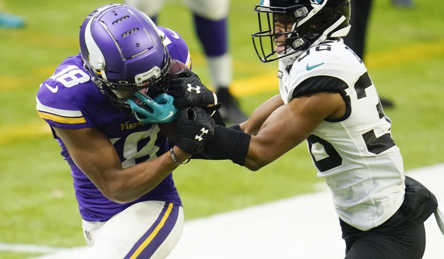 Minnesota Vikings wide receiver Justin Jefferson, left, catches a pass in front of Jacksonville Jaguars cornerback Luq Barcoo, right, during the second half of an NFL football game, Sunday, Dec. 6, 2020, in Minneapolis. (AP Photo/Jim Mone)
