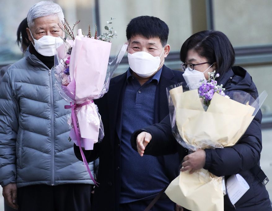 Yoon Seong-yeo, 53, center, is congratulated at the Suwon District Court in Suwon, South Korea, Thursday, Dec. 17, 2020. Yoon who spent 20 years behind bars for a murder he didn't commit has cleared his name in court after one of the country's most notorious serial killers confessed to the 1988 rape and murder of a 13-year-old girl. Yoon had been sentenced to life in prison and was released on parole in 2009. He listened quietly as the judge apologized to him on behalf of the judiciary for causing him "immense physical and mental pain" because of the wrong verdict. (Hong Ki-won/Yonhap via AP)