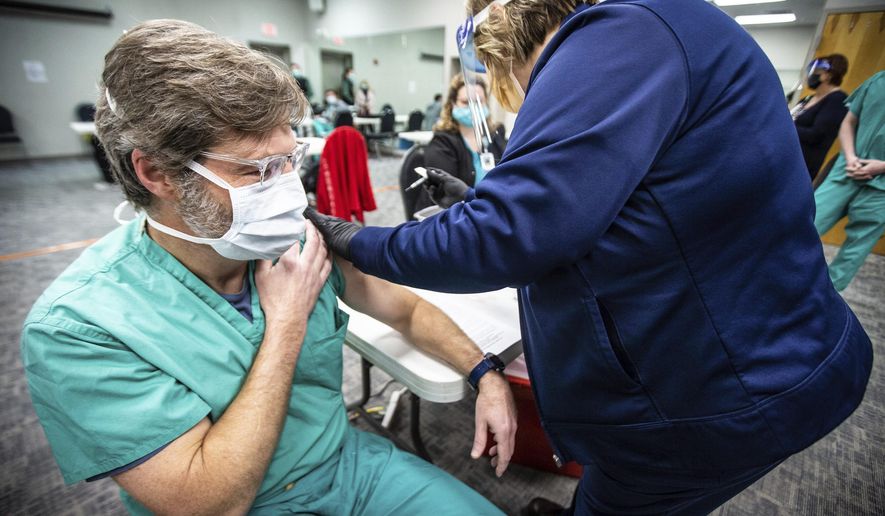 Dr. Lynn Ridgeway, a pulmonologist, pulls up his sleeve as he receives one of the first Pfizer-BioNTech COVID-19 vaccines given to front line workers at Helen Keller Hospital on Thursday, Dec. 17, 2020, in Sheffield, Ala. [Dan Busey /The TimesDaily via AP)