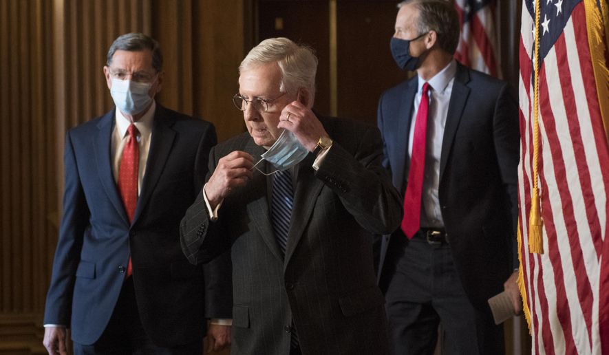Senate Majority Leader Mitch McConnell of Ky., removes his face mask as he arrives with Sen. John Barrasso, R-Wyo., left, and John Thune, R-S.D., right, for a news conference with other Senate Republicans on Capitol Hill in Washington, Tuesday, Dec. 15, 2020. (Rod Lamkey/Pool via AP)