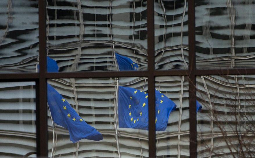 European Union flags are reflected in a window of the European Council in Brussels, Saturday, Dec. 19, 2020. The European Union and the United Kingdom were starting a "last attempt" to clinch a post-Brexit trade deal, with EU fishing rights in British waters the most notable remaining obstacle to avoid a chaotic and costly changeover on New Year. (AP Photo/Virginia Mayo)