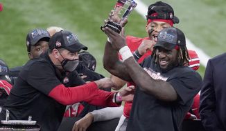 Ohio State running back Trey Sermon, right, is congratulated by head coach Ryan Day, left, after being named most valuable player following the Big Ten championship NCAA college football game, Saturday, Dec. 19, 2020, in Indianapolis. Ohio State defeated Northwestern 22-10. (AP Photo/Darron Cummings)