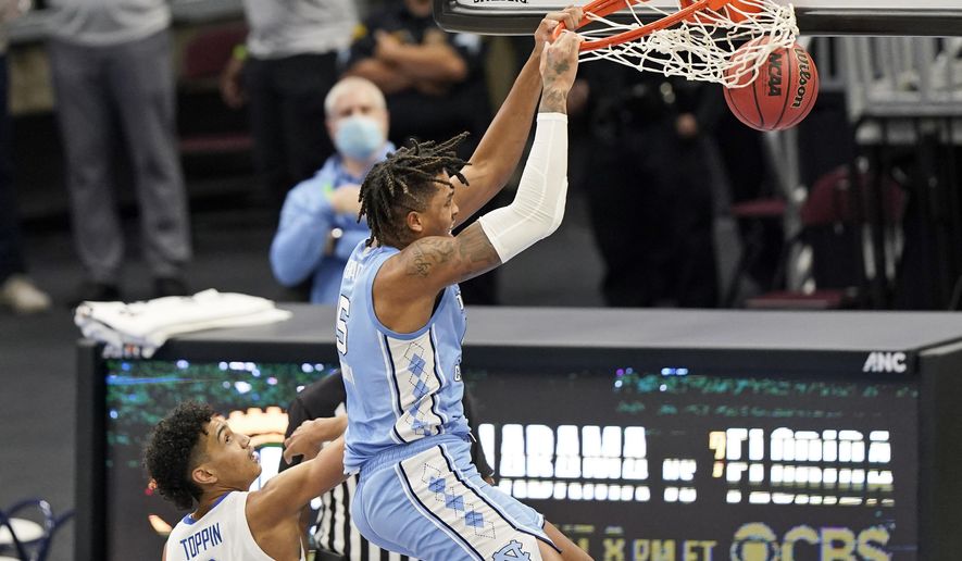 North Carolina's Armando Bacot (5) dunks the ball over Kentucky's Jacob Toppin (0) in the second half of an NCAA college basketball game, Saturday, Dec. 19, 2020, in Cleveland. North Carolina won 75-63. (AP Photo/Tony Dejak)