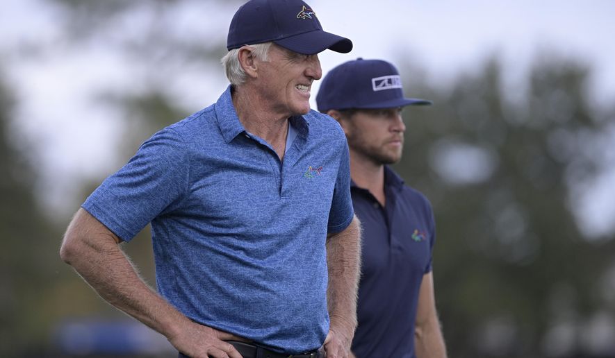 Greg Norman, left, of Australia, walks with his son Greg Norman Jr. on the 18th fairway after hitting their tee shots during the first round of the PNC Championship golf tournament, Saturday, Dec. 19, 2020, in Orlando, Fla. (AP Photo/Phelan M. Ebenhack)