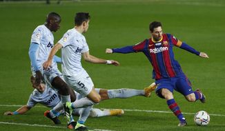 Barcelona&#39;s Lionel Messi, right, takes a shot at goal during the Spanish La Liga soccer match between Barcelona and Valencia at the Camp Nou stadium in Barcelona, Spain, Saturday, Dec. 19, 2020. (AP Photo/Joan Monfort)
