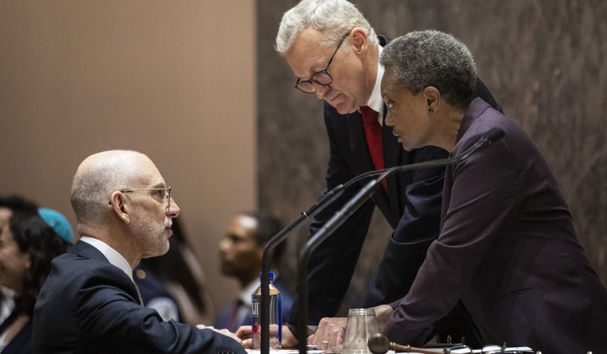 File-This May 29, 2019, file photo shows Chicago Mayor Lori Lightfoot, right, chatting with Corporation Counsel Mark Flessner, center, and Deputy Corporation Counsel Jeff Levine during her first city council meeting at City Hall in Chicago. Flessner, Chicago’s top attorney resigned Sunday, Dec. 20, 2020, in the fallout of a botched police raid on the home of a Black woman who was not allowed to put on clothes before being handcuffed. Flessner announced the move in an email to employees, saying he was only recently involved with the legal case connected to a police video of the February 2019 wrongful raid on the home of social worker Anjanette Young. Flessner did not say if he was asked to resign. (Ashlee Rezin/Chicago Sun-Times via AP, File)
