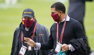 Washington Football Team owner Dan Snyder, left, walking on the field with Team President Jason Wright, right, before the start of an NFL football game against the Seattle Seahawks, Sunday, Dec. 20, 2020, in Landover, Md. (AP Photo/Susan Walsh) **FILE**