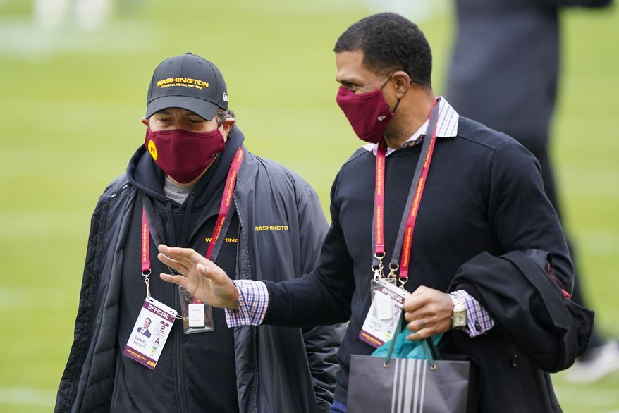 Washington Football Team owner Dan Snyder, left, walking on the field with Team President Jason Wright, right, before the start of an NFL football game against the Seattle Seahawks, Sunday, Dec. 20, 2020, in Landover, Md. (AP Photo/Susan Walsh) **FILE**