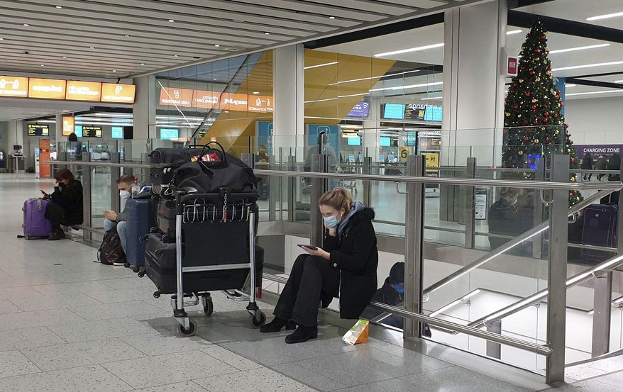 Passengers wait at Gatwick Airport in West Sussex, England, Sunday Dec. 20, 2020. One by one, several European Union nations have banned flights from the U.K. and others were considering similar action, in a bid to block a new strain of coronavirus sweeping across southern England from establishing a strong foothold on the continent. (Gareth Fuller/PA via AP)