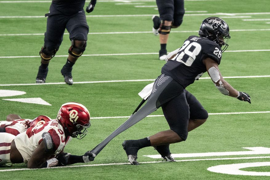 Oklahoma defensive end Marcus Stripling (33) tries to bring down Iowa State running back Breece Hall (28) by the shirt during the second half of the Big 12 Conference championship NCAA college football game, Saturday, Dec. 19, 2020, in Arlington, Texas. Oklahoma won 27-21. (AP Photo/Jeffrey McWhorter)