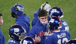 New York Giants quarterback Daniel Jones, center, talks to quarterback Colt McCoy (12) during the first half of an NFL football game against the Cleveland Browns, Sunday, Dec. 20, 2020, in East Rutherford, N.J. (AP Photo/Corey Sipkin)