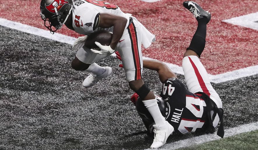 Tampa Bay Buccaneers wide receiver Antonio Brown, top, gets past Atlanta Falcons cornerback Tyler Hall for what proved to be the winning touchdown in the final minutes of an NFL football game Sunday, Dec. 20, 2020, in Atlanta. (Curtis Compton/Atlanta Journal-Constitution via AP)