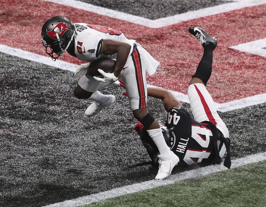 Tampa Bay Buccaneers wide receiver Antonio Brown, top, gets past Atlanta Falcons cornerback Tyler Hall for what proved to be the winning touchdown in the final minutes of an NFL football game Sunday, Dec. 20, 2020, in Atlanta. (Curtis Compton/Atlanta Journal-Constitution via AP)