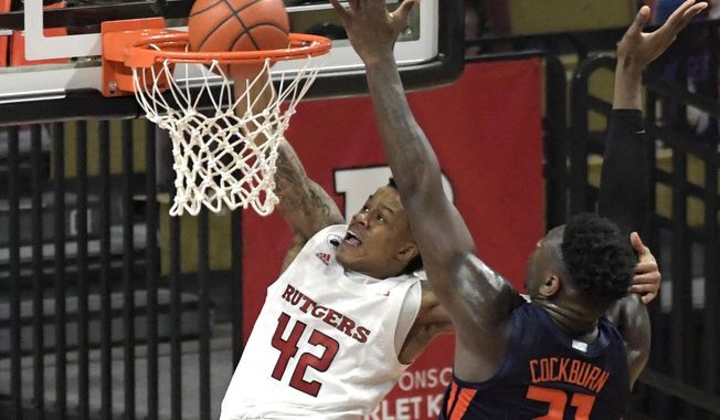 Rutgers guard Jacob Young (42) attempts to dunk the ball over Illinois center Kofi Cockburn (21) during the first half of an NCAA college basketball game Sunday, Dec. 20, 2020, in Piscataway, N.J. (AP Photo/Bill Kostroun)