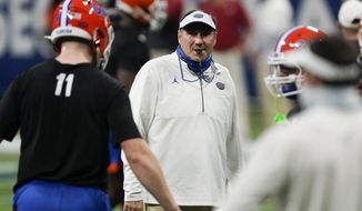 Florida head coach Dan Mullen speaks with players before the first half of the Southeastern Conference championship NCAA college football game between Florida and Alabama, Saturday, Dec. 19, 2020, in Atlanta. (AP Photo/John Bazemore)