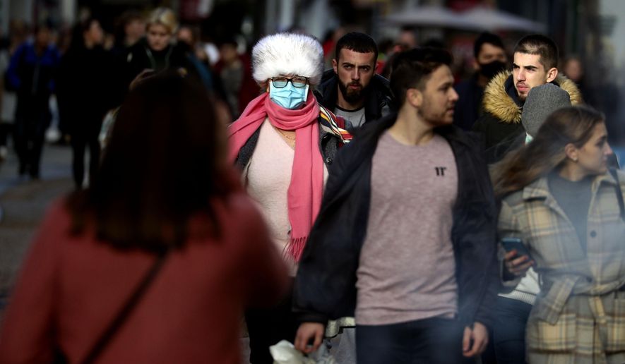Christmas shoppers in Oxford city centre England, Sunday Dec. 20, 2020. Millions of people in England have learned they must cancel their Christmas get-togethers and holiday shopping trips. British Prime Minister Boris Johnson said Saturday that holiday gatherings can’t go ahead and non-essential shops must close in London and much of southern England. (Steve Parsons/PA via AP)