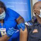 Lt. Ollie Martin, right, with Ochsner Security, is inoculated with the Pfizer-BioNTech COVID-19 vaccine by nurse Meshoca Williams at Ochsner Hospital on O&#39;Neal Lane, Tuesday, Dec. 15, 2020, in Baton Rouge, La. (Bill Feig/The Advocate via AP, Pool)