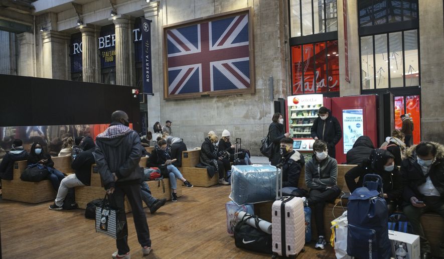 Passengers wearing face mask wait next to the Eurostar Terminal at Gare du Nord train station in Paris, Monday Dec. 21, 2020. France is banning all travel from the U.K. for 48 hours in an attempt to make sure that a new strain of the coronavirus in Britain doesn&#x27;t reach its shores. (AP Photo/Lewis Joly)