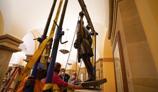 This Monday, Dec. 21, 2020, photo provided by the Office of the Governor of Virginia shows workers removing a statue of Confederate Gen. Robert E. Lee from the National Statuary Hall Collection in Washington. The statue that has represented Virginia in the U.S. Capitol for 111 years has been removed after a state commission decided that Lee was not a fitting symbol for the state. (Jack Mayer/Office of Governor of Virginia, File)