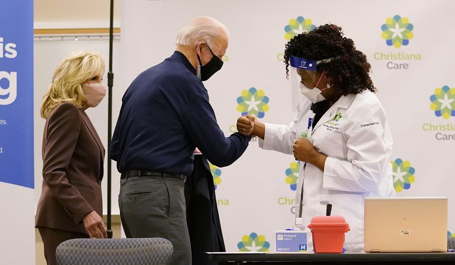 President-elect Joe Biden fist bumps with nurse practitioner Tabe Mase after receiving his first dose of the coronavirus vaccine at ChristianaCare Christiana Hospital in Newark, Del., Monday, Dec. 21, 2020, as Jill Biden looks on. (AP Photo/Carolyn Kaster)
