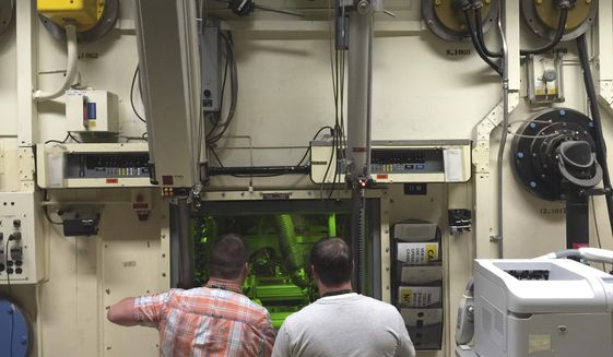 FILE - In this May 11, 2015, file photo, Colt Killian, left, and Rob Cox manipulate radioactive material remotely behind a protective barrier at the Hot Fuel Examination Facility at the Idaho National Laboratory near Idaho Falls, Idaho. Idaho is the top choice for the first new nuclear test reactor in the U.S. in decades. The U.S. Department of Energy on Monday, Dec. 21, 2020, released a draft environmental impact statement saying the Idaho National Laboratory is its preferred site for the proposed Versatile Test Reactor. (AP Photo/Keith Ridler, File)