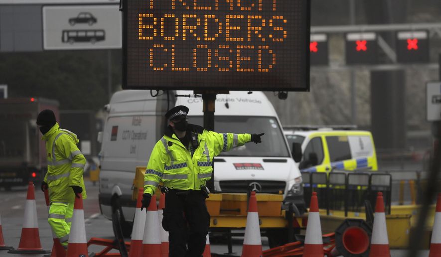 A police officer directs traffic at the entrance to the closed ferry terminal in Dover, England, Monday, Dec. 21, 2020, after the Port of Dover was closed and access to the Eurotunnel terminal suspended following the French government&#x27;s announcement. France banned all travel from the UK for 48 hours from midnight Sunday, including trucks carrying freight through the tunnel under the English Channel or from the port of Dover on England&#x27;s south coast. (AP Photo/Kirsty Wigglesworth)