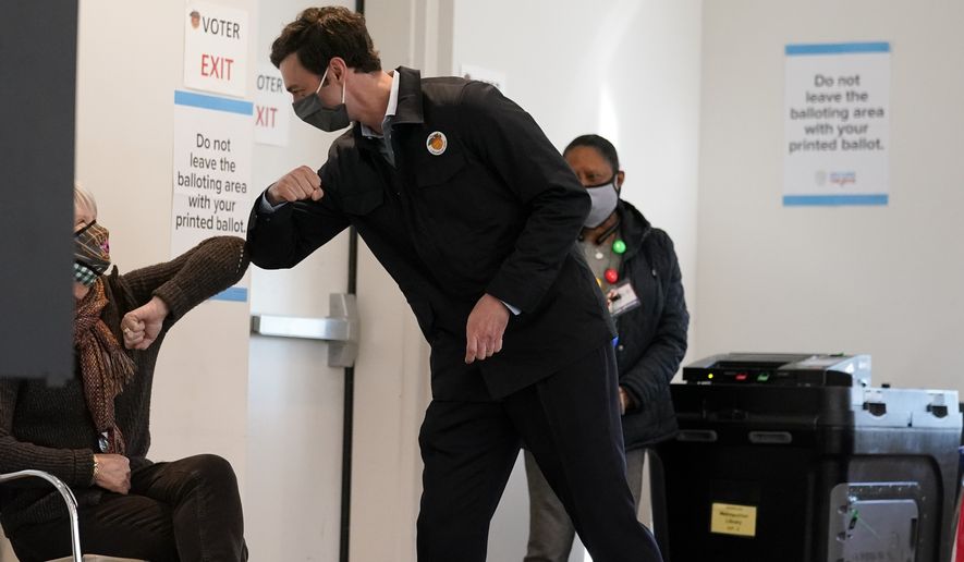Democratic nominee for U.S. Senate from Georgia Jon Ossoff greets a poll worker after voting early in Atlanta on Tuesday, Dec. 22, 2020. For the second time in three years, Jon Ossoff is campaigning in overtime. The question is whether the 33-year-old Democrat can deliver a win in a crucial Jan. 5 runoff with Republican Sen. David Perdue. (AP Photo/John Bazemore)