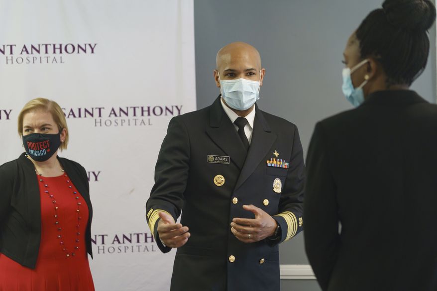 U.S. Surgeon General Jerome Adams, center, is joined by Chicago Health Commissioner Dr. Allison Arwady, left, and Illinois Public Health Director Dr. Ngozi Ezike during their visit at Saint Anthony Hospital in Chicago, Tuesday, Dec. 22, 2020. (Youngrae Kim/Chicago Tribune via AP, Pool)