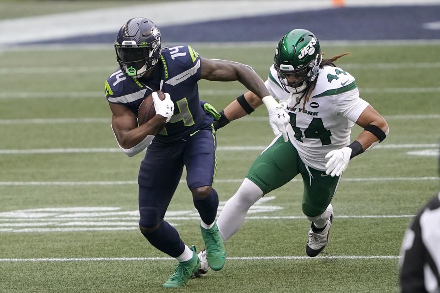 Seattle Seahawks wide receiver DK Metcalf (14) runs with the ball as New York Jets inside linebacker Harvey Langi gives chase during the first half of an NFL football game, Sunday, Dec. 13, 2020, in Seattle. (AP Photo/Ted S. Warren)