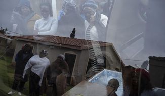 Mourners look at the body of 5-year-old Wandi Zitho at his funeral in Orange Farm, South Africa, on April 28, 2020. The boy was murdered in a suspected witchcraft ritual and his body was found in his neighbor&#39;s tavern. (AP Photo/Bram Janssen)