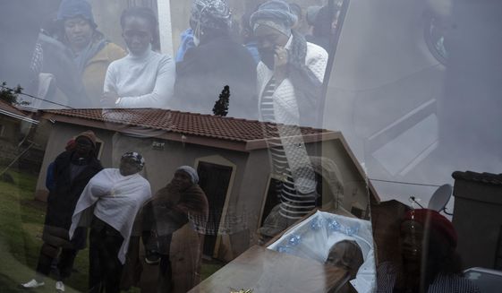 Mourners look at the body of 5-year-old Wandi Zitho at his funeral in Orange Farm, South Africa, on April 28, 2020. The boy was murdered in a suspected witchcraft ritual and his body was found in his neighbor&#x27;s tavern. (AP Photo/Bram Janssen)