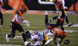 Cincinnati Bengals&#39; Vonn Bell (24) and Jordan Evans (50) look to recover a fumble by Pittsburgh Steelers&#39; JuJu Smith-Schuster (19) during the first half of an NFL football game, Monday, Dec. 21, 2020, in Cincinnati. (AP Photo/Bryan Woolston)