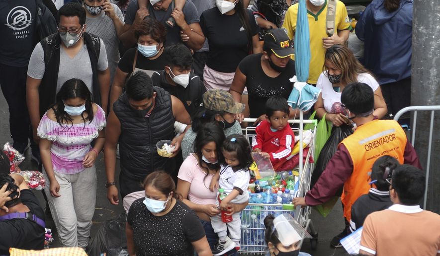 Pedestrians wearing face masks amid the COVID-19 pandemic walk in the Mesa Redonda Market, a popular spot for Christmas shopping in Lima, Peru, Friday, Dec. 18, 2020. Peru&#39;s Health Ministry has announced on Tuesday, Dec. 22, that it has surpassed 1 million confirmed cases of the new coronavirus. (AP Photo/Martin Mejia, File)