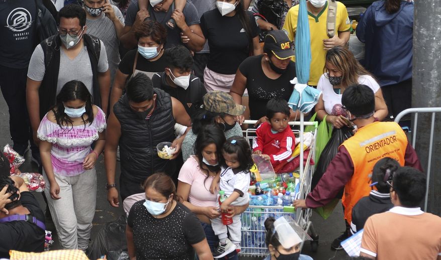 Pedestrians wearing face masks amid the COVID-19 pandemic walk in the Mesa Redonda Market, a popular spot for Christmas shopping in Lima, Peru, Friday, Dec. 18, 2020. Peru&#39;s Health Ministry has announced on Tuesday, Dec. 22, that it has surpassed 1 million confirmed cases of the new coronavirus. (AP Photo/Martin Mejia, File)