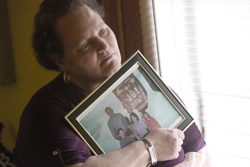 Christina Grim holds a family photograph that includes her mother, Verl Grim, top right, on Saturday, Dec. 19, 2020, at her home in Littlestown, Pa. Grim contends that an H1N1 vaccination triggered her mother’s Guillain-Barre syndrome, an immune system disorder that caused her death in 2010. But she missed a one-year deadline for filing and her claim to the federal Countermeasures Injury Compensation Program was denied. (AP Photo/Steve Ruark)