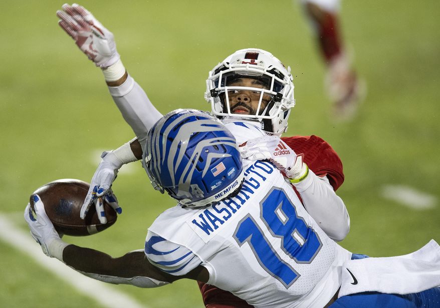 Memphis wide receiver Tahj Washington (18) makes a reception against Florida Atlantic cornerback Diashun Moss during the Montgomery Bowl NCAA college football game in Montgomery, Ala., Wednesday, Dec. 23, 2020. (Mickey Welsh/The Montgomery Advertiser via AP)